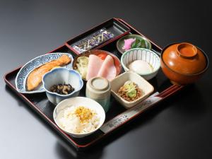 OwariasahiにあるTabist さもと館 尾張旭のテーブルの上にさまざまな種類の食べ物が載ったトレイ