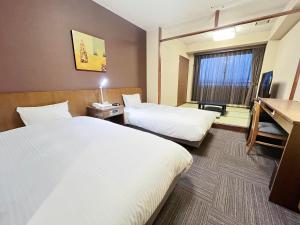 Postel nebo postele na pokoji v ubytování Route Inn Grantia Hidatakayama Wakura no yado