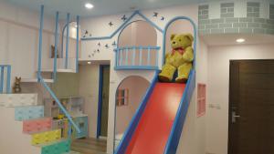 a stuffed teddy bear sitting on a slide in a play room at Sun Shine B&B in Hengchun