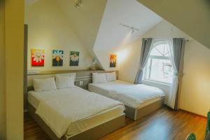 a bedroom with two beds and a window at Hotel Tường Vy 3 in Da Lat +101 photos
