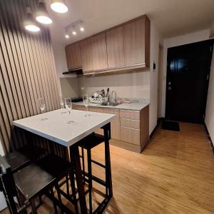 a kitchen with a table with wine glasses on it at Jellyrei Davao Condo in Davao City