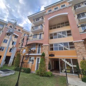 an apartment building with pink and yellow at Jellyrei Davao Condo in Davao City