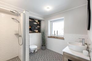 une salle de bain blanche avec un lavabo et des toilettes dans l'établissement Deichlodge-4, à Büsumer Deichhausen 19 autres photos