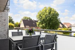 une terrasse avec une table et des chaises sur un balcon dans l'établissement Deichlodge-4, à Büsumer Deichhausen