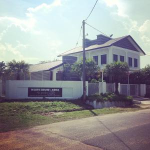 a white house with a sign in front of it at WHG Homestay, Paya Berenjut Kemaman in Cukai