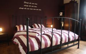 a bedroom with a bed with a striped comforter at Door & Roos in Lottum