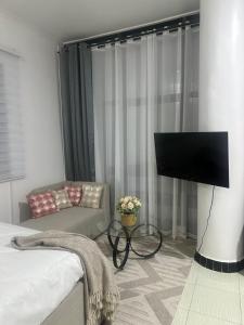 a living room with a tv and a couch at Urban Studio Room in Dar es Salaam