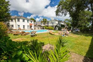 a yard with a swimming pool and people sitting at Les Douvres Hotel in St Martin Guernsey