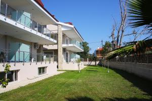 un gran edificio blanco con un patio delante en Toroni Luxury Villas, en Toroni