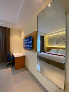 a bedroom with a bed and a desk and a mirror at Wisma HN in Selang