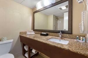 a bathroom with a sink and a mirror and a toilet at Clarion Pointe Research Triangle Park Durham in Durham +24 photos