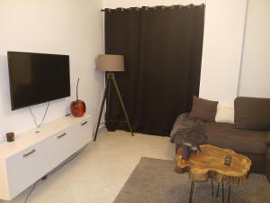 a living room with a couch and a flat screen tv at Hurghada HOME in Hurghada