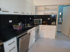 a kitchen with white cabinets and a black counter top at Hurghada HOME in Hurghada