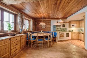 グロースアルルにあるFerienhaus Grabenhäuslの木製の天井、テーブルと椅子付きのキッチンが備わります。