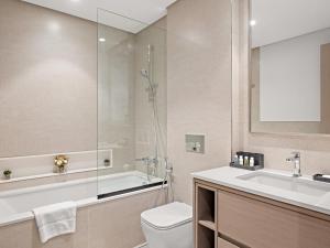 een badkamer met een bad, een toilet en een wastafel bij SKY9 Apartments - Luxury Apartments in Downtown Dubai with Full Burj Khalifa View in Dubai