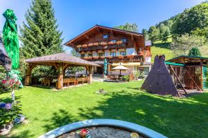 duży budynek z ogródkiem z domem w obiekcie Hotel - Pension Ötzmooshof w mieście Sankt Johann im Pongau