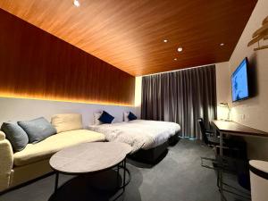 白浜町にあるBakery Hotel SHIRAHAMA ベーカリーホテル シラハマのベッドとソファのあるホテルの部屋