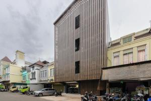a building with a wooden facade on a city street at Urbanview Hotel Vineyard Cengkareng in Jakarta