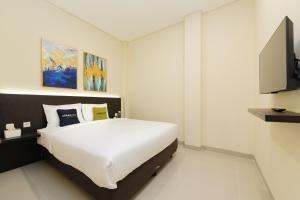 a bedroom with a bed and a flat screen tv at Urbanview Hotel Vineyard Cengkareng in Jakarta +17 photos