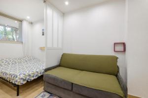 een slaapkamer met een bank en een bed erin bij Studio - 2 couchages doubles in Villeneuve-Loubet