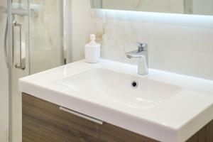 een witte wastafel met een zeepfles erop bij Studio - 2 couchages doubles in Villeneuve-Loubet +15 foto's