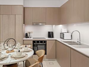 een keuken met een tafel met stoelen en een magnetron bij SKY9 Apartments - Luxury Apartments in Downtown Dubai with Full Burj Khalifa View in Dubai