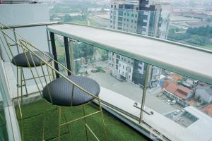 two chairs sitting on the edge of a balcony at Comfort and Modern Studio at Tree Park Cikokol Apartment By Travelio in Tangerang