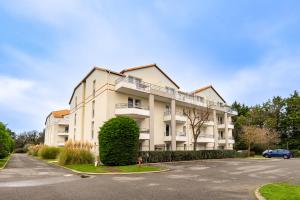 a large white building with a parking lot at 123 - Charme, piscine et évasion in Pornic