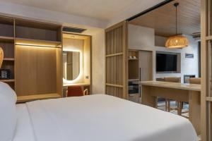 a hotel room with a white bed and a kitchen at Radisson Blu Hotel, Kas in Kaş