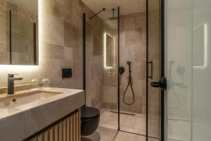 a bathroom with a shower with a sink and a toilet at Radisson Blu Hotel, Kas in Kaş