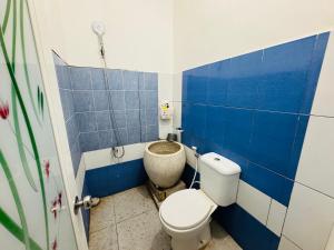 a bathroom with a toilet and a blue tiled wall at Mulia Homestay Syariah Pasuruan in Randusari +11 photos