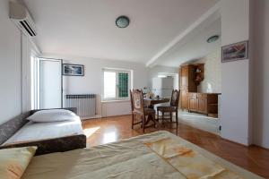 a bedroom with a bed and a kitchen with a table at Apartments in Turanj 150 meters from the sea - By TA Leut Agency in Turanj