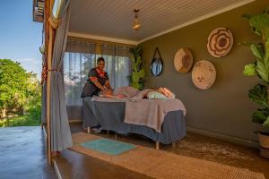 a man standing next to a bed in a room at Muluwa Lodge in White River