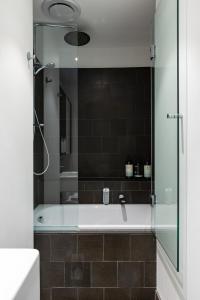 メルボルンにあるPenthouse Apartment Collingwoodのバスルーム(ガラス張りのシャワーブース付きのバスタブ付) +37枚の写真