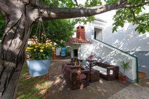 a patio with couches and a table and a tree at Apartments in Turanj 150 meters from the sea - By TA Leut Agency in Turanj