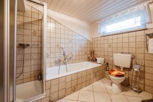 a bathroom with a tub and a toilet and a sink at Haus Josef Hager in Bad Füssing +16 photos