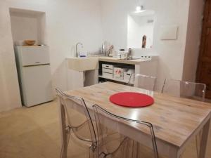 a kitchen with a table with chairs and a red plate on it at Palazzo delle favole in Ostuni