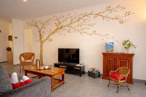a living room with a tree mural on the wall at Les Chaudannes in La Croix-de la Rochette