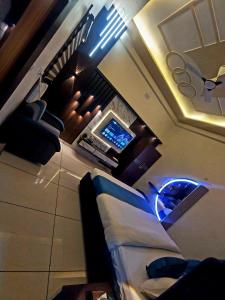 a living room with a couch and a tv at Hotel Moon in Mahoba