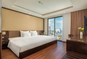 a bedroom with a large bed and a large window at Palazzo Boutique Hotel in Danang