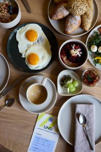 una mesa cubierta con platos de huevos y comida en Hotel UND - smart alpine stay, en Schladming