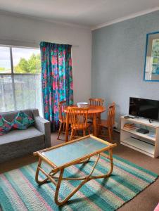 a living room with a couch and a table and chairs at Jamaed Court in George