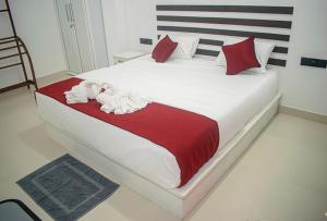 a bedroom with a large bed with red and white sheets at Sanasa Villa Weligama in Weligama