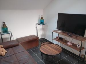 a living room with a couch and a flat screen tv at La bonne adresse in Woippy