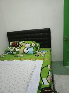 a bed with a hello kitty comforter and pillows at GS Homestay Banyuwangi in Banyuwangi +4 photos
