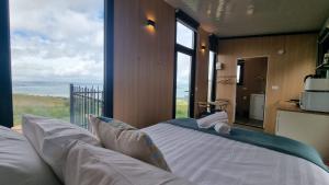 a bedroom with a bed with a view of the ocean at Aorangi Peak Cabins 6 by Tiny Away in Rotorua