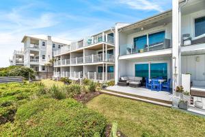 an exterior view of a large white apartment building at The Good Life in Inlet Beach
