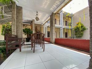 a balcony with chairs and tables on a building at Surya Guest House Urbanview Probolinggo in Kanigaran