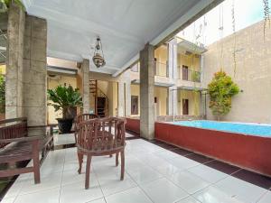 a patio with a bench and a swimming pool at Surya Guest House Urbanview Probolinggo in Kanigaran