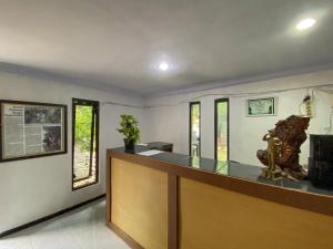 a bar in a room with a counter and some windows at Surya Guest House Urbanview Probolinggo in Kanigaran